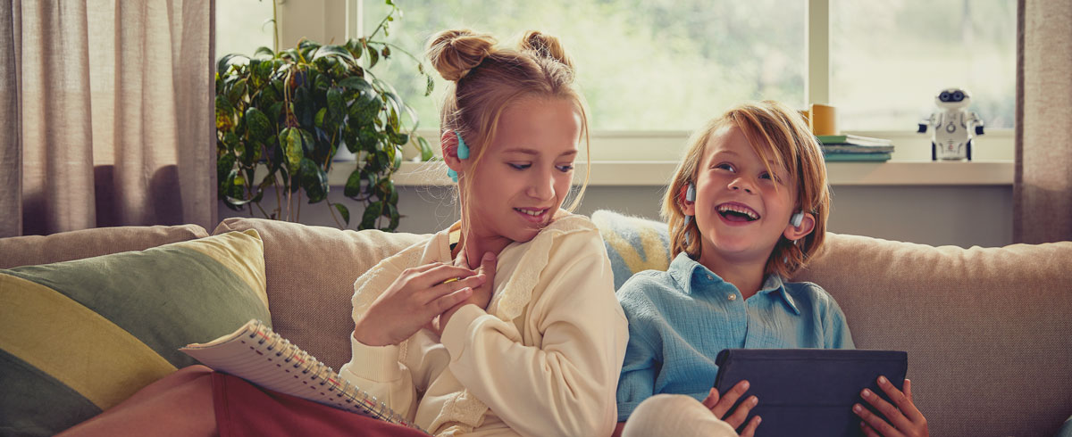 Barn som liker en video med Philips-barnehodetelefoner med &aring;pent &oslash;re