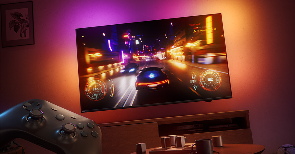 Et racingspill vises p&aring; en Philips Ambilight-TV i et svakt opplyst rom